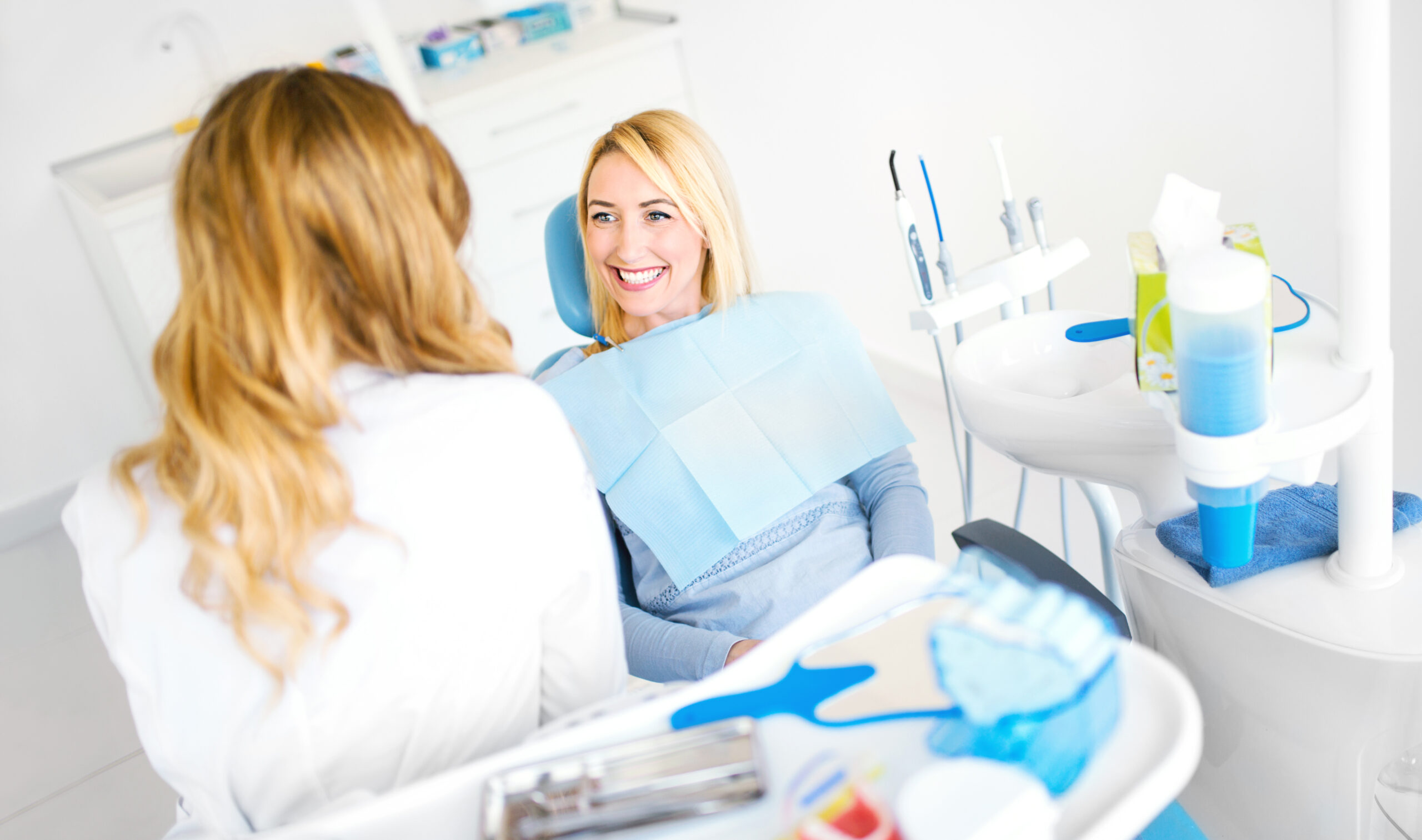 Young female patient listening to what her dentist have to say about painless procedure and she's happy with what she heard.