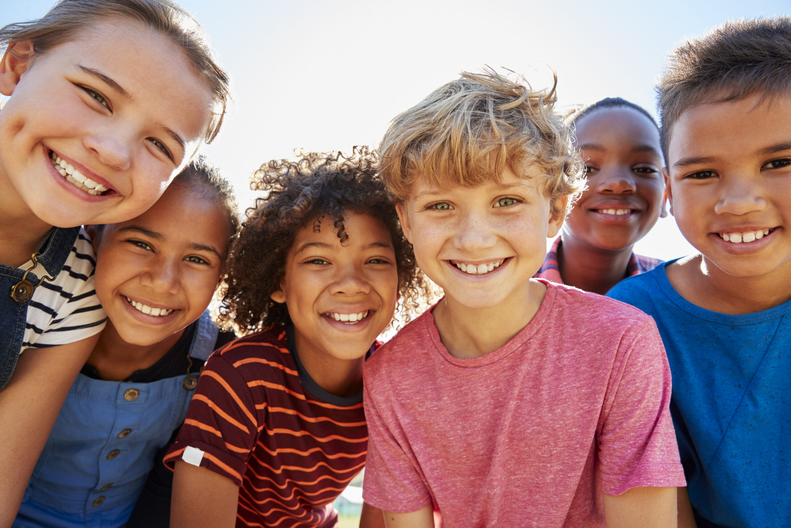 Group of smiling pre-teen friends outdoors showing healthy smiles, kids' dental care at Innovative Dental & Orthodontics, family dentist in Oviedo